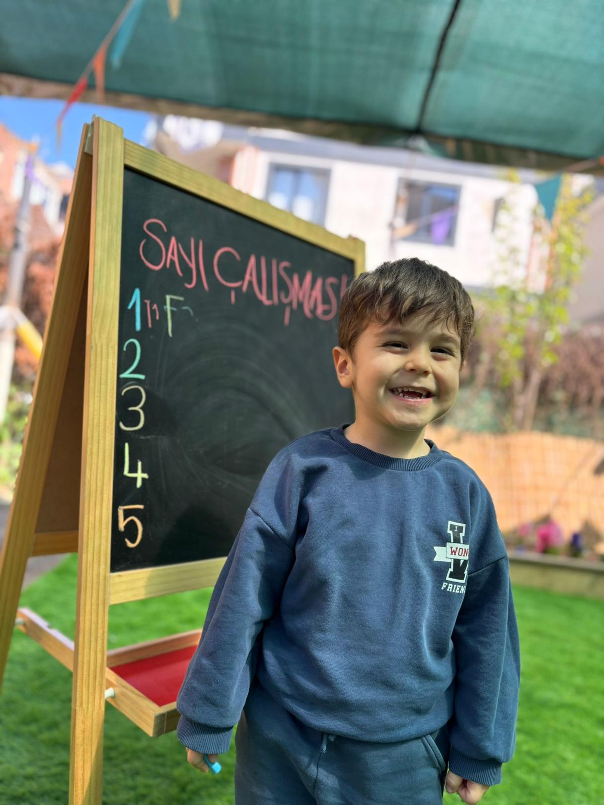 Bahçede sayı çalışması yapan mutlu çocuk